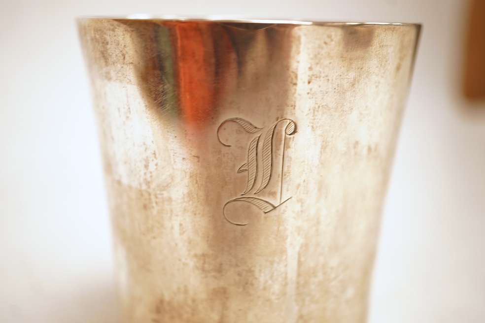 A white metal beaker the base inset with a silver medal commemorating the Peace of Oliva, 1660, Obv. Bird's-eye view of the city of Danzig with troops moving in foreground; above, an eagle crowned, an olive branch in its
